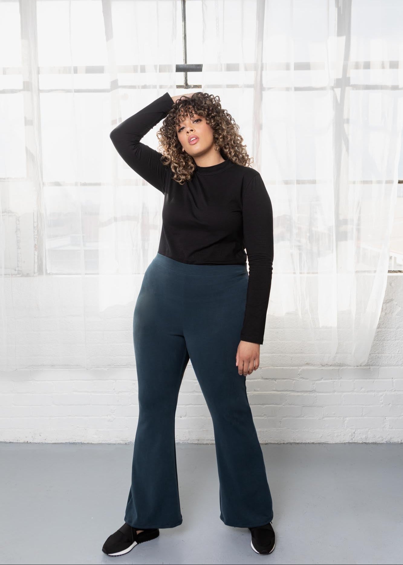 Blue flare pants on plus size model.